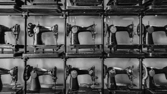 Grid of vintage sewing machines in a black and white photo